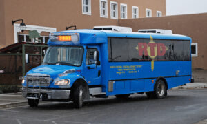 The blue bus shuttle leaving a stop for Taos Ski Valley