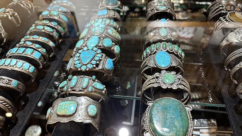 A lavish display of sterling silver and turquoise bracelets in a glass case.