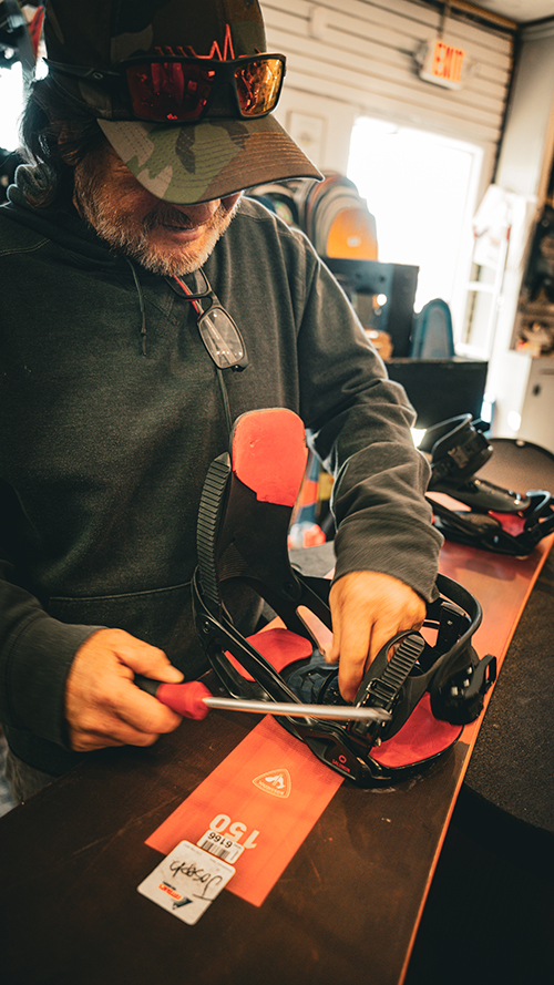 A tuner works on a snowboard.