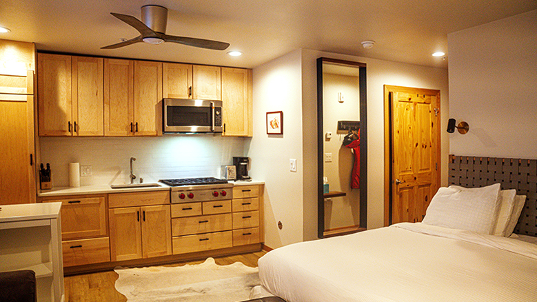 A studio hotel room with a kitchenette and full stovetop.