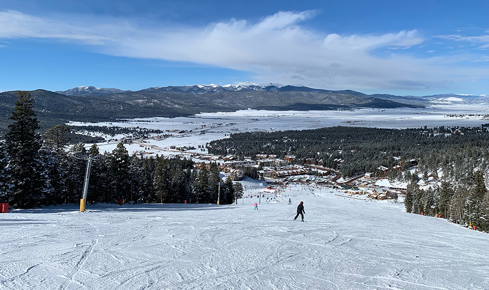 A wide open ski hill on a sunny day.