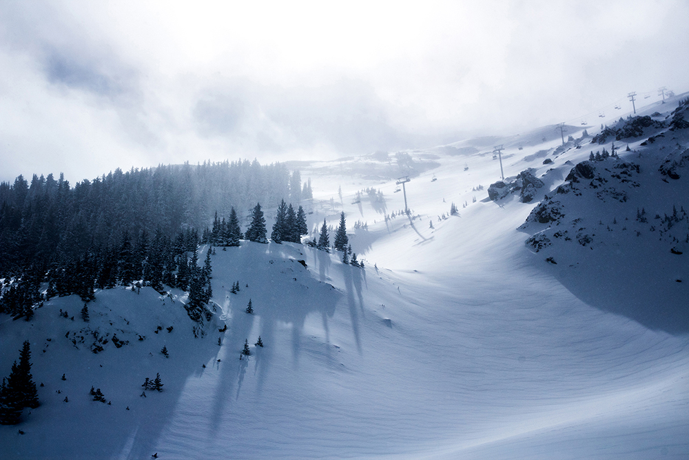 A smooth blanket of powdery snow covers ski slopes early in the morning.