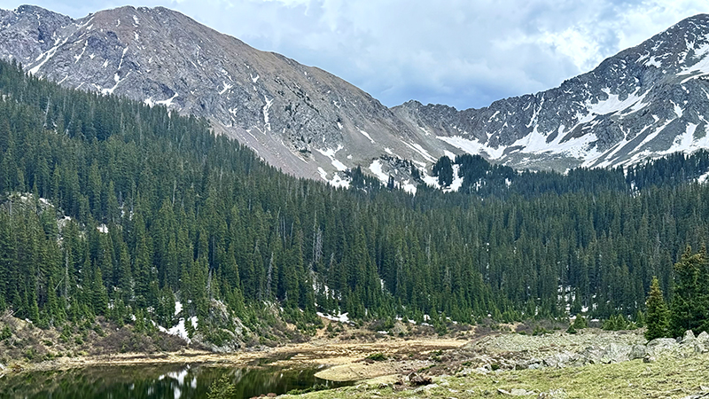 A small alpine lake sits in a bowl of treeless mountain tops.