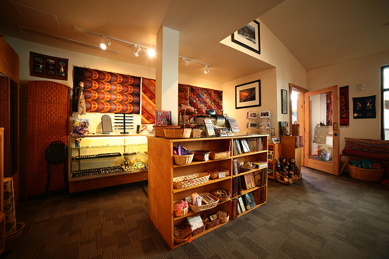 Interior shot of a jewlery and gift shop with high ceilings and warm lighting.