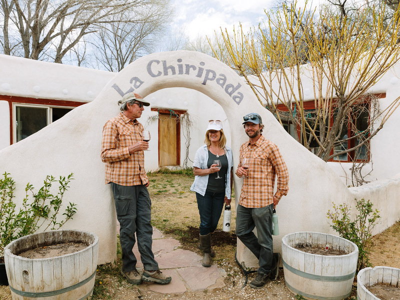 People standing with wine glasses near archway