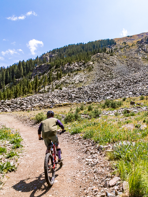 Person riding a bike up a mountain trail