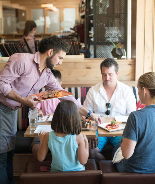 A waiter serves a family lunch.