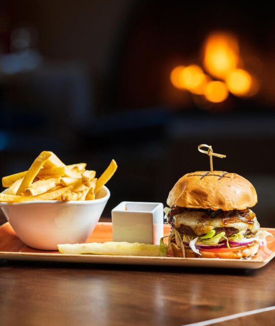 Cheeseburger and fries in front of a fireplace