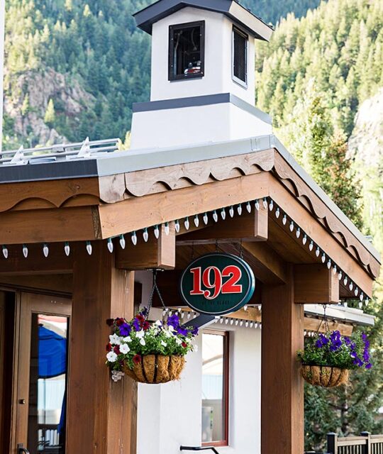 192 entrance at Taos resort plaza in the summer with hanging flower baskets.