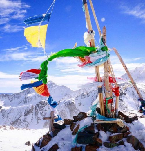 Colorful prayer flag fly on top of Kachina Peak in Taos Ski Valley