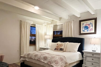 A white bedroom with white bedding from Abode Vacation Rentals