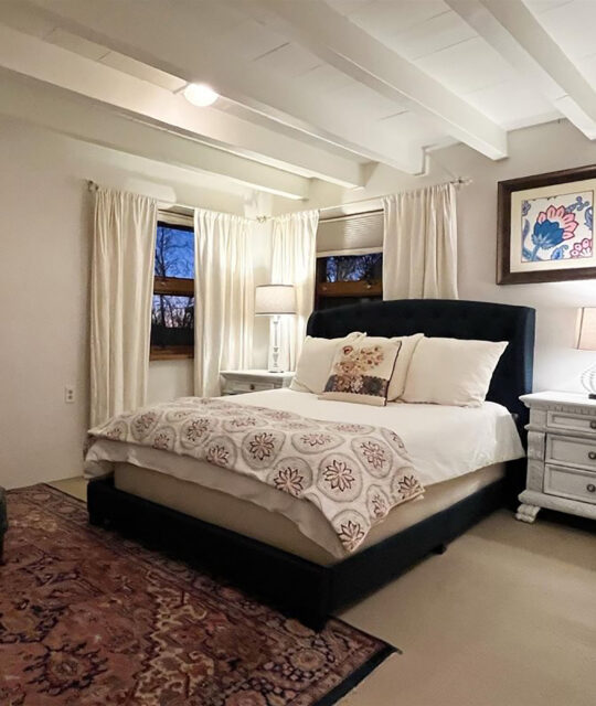 A white bedroom with white bedding from Abode Vacation Rentals