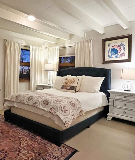 A white bedroom with white bedding from Abode Vacation Rentals