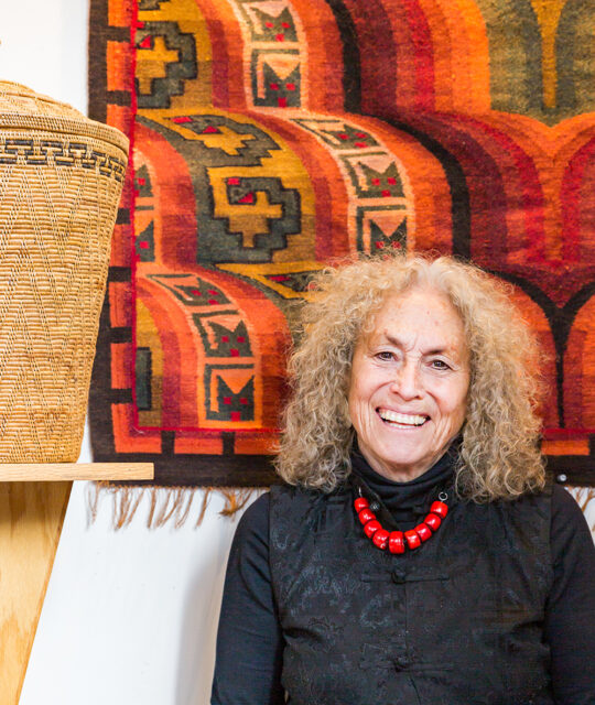 Andean Software owner smiling in front of woven rug