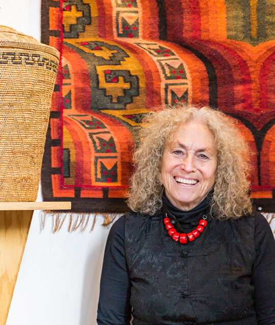 Andean Software owner Andrea Heckman in front of woven rug