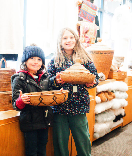 Children holding South American baskets.