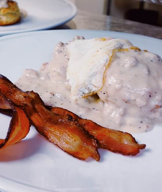 Biscuits & sausage gravy topped with an egg and bacon