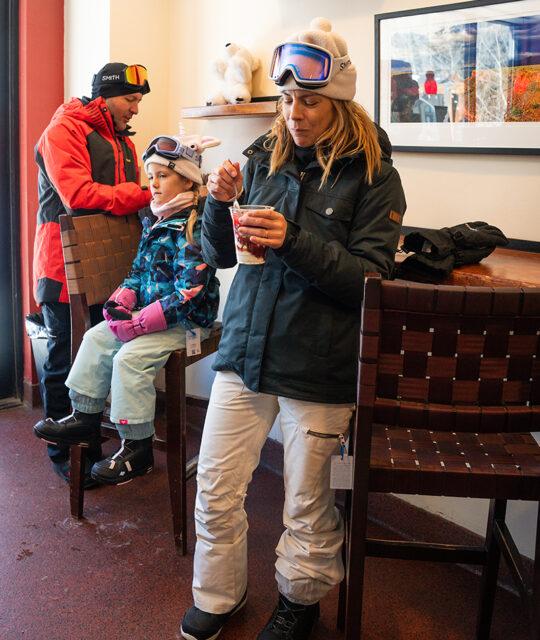 Family in ski gear in an espresso bar.