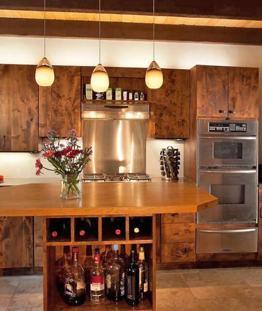 Modern kitchen with wood accents and central island bar.