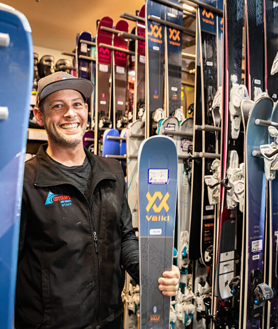 Ski shop rental employee with skis
