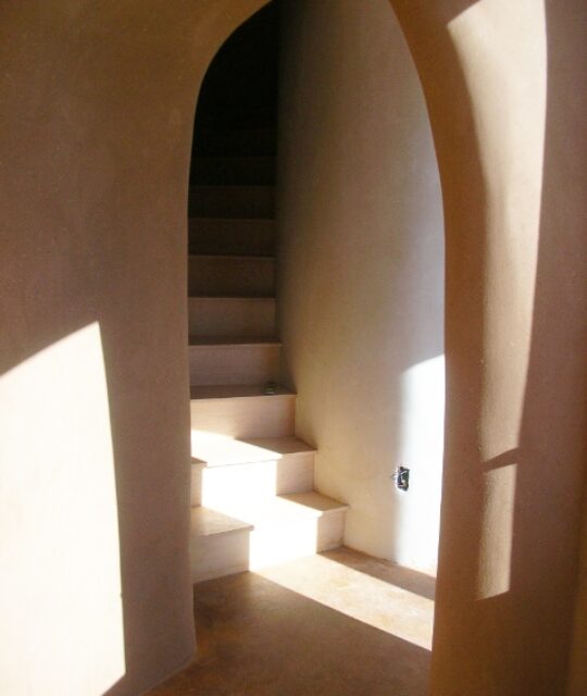 Light and shadows falling on adobe staircase.