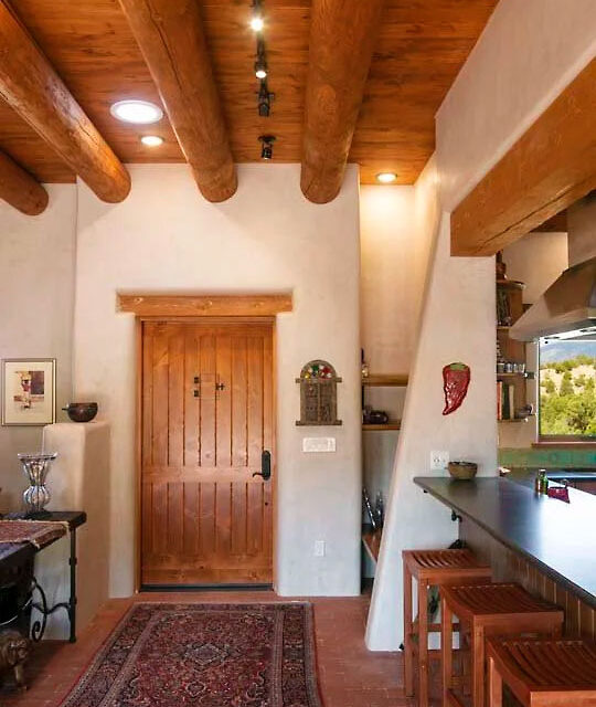 A Southwest Traditional residential home interior with viga ceilings and adobe.