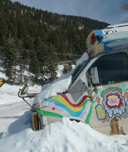 Colorful school bus in snowy RV and camper parking lot.