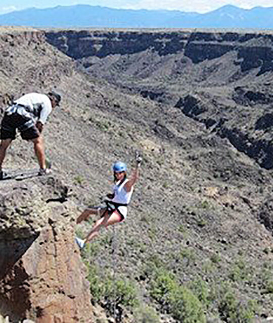 Woman rappelling in the rio grande gorge,