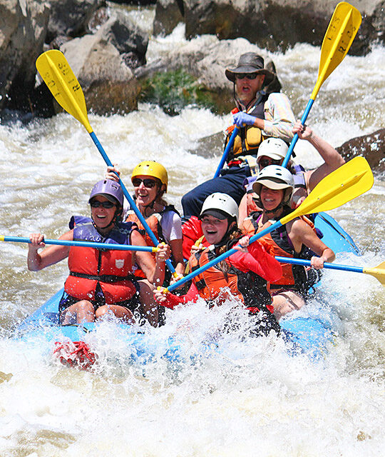 Rafters with paddles up in the Rio Grande river in New Mexico