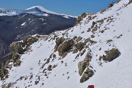 Backcountry skier in Taos with Gold Hill in background
