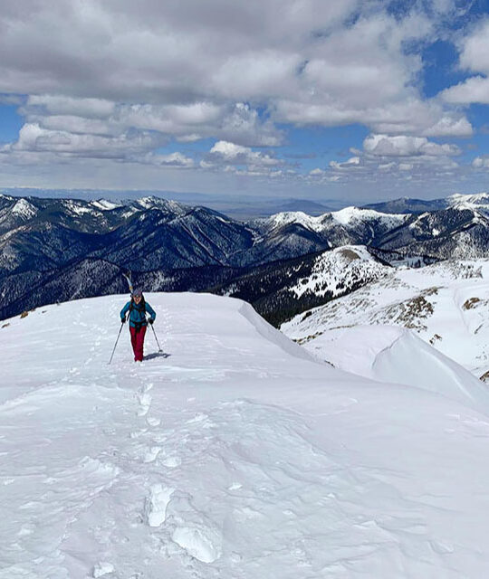 Backcountry skier with beautiful view of Taos mountains