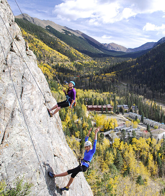Girls rappelling in Taos Ski Valley in fall colors
