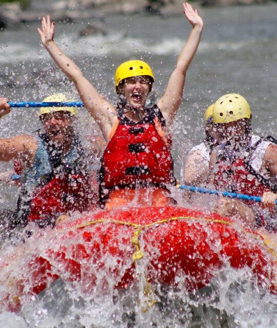 Exuberant woman whitewater rafting.