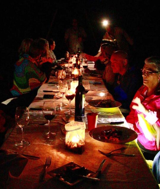 Couples dining outside at night at a wine pairing dinner.