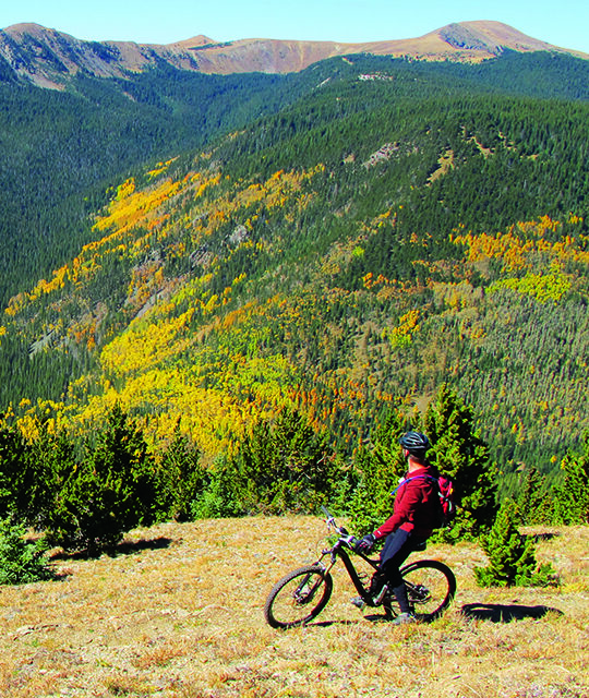 Mountain biker enjoying the fall color view in Taos Ski Valley