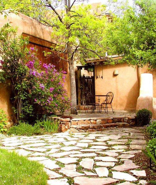 Beautiful courtyard of an adobe home with trees blossoming