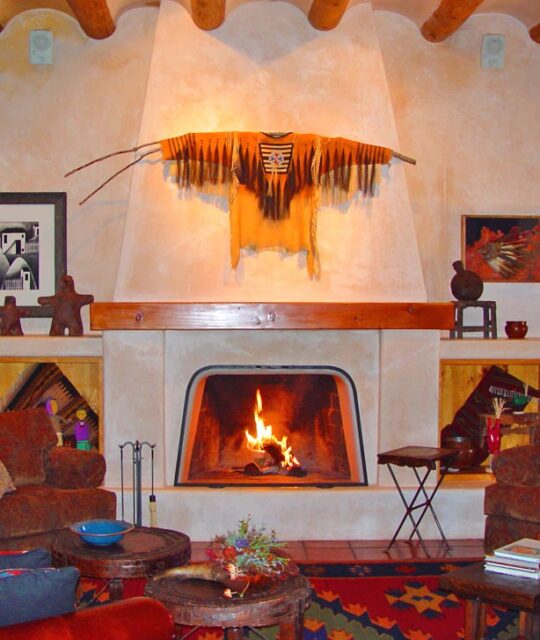 A large adobe fireplace and art in adobe home