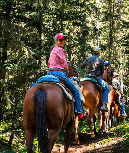 Smiling woman on a horseback ride with Rio Grande Stables.