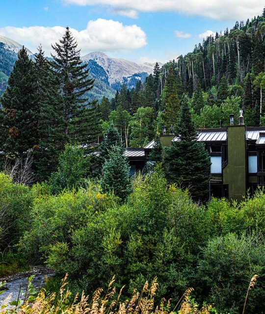 Summer exterior of the Rio Hondo Condominiums with view of the mountains.