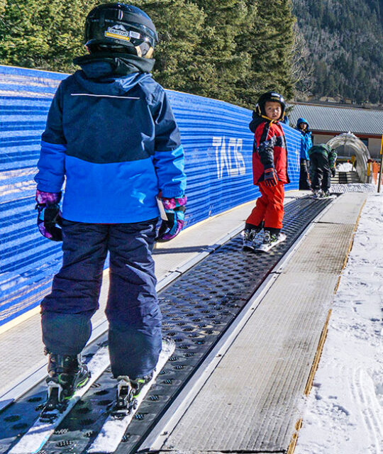 Children riding the magic carpet lift at Taos Ski Valley
