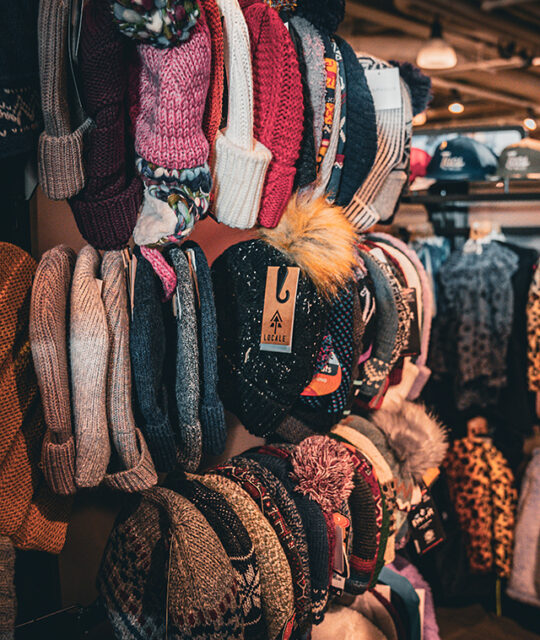 Warm winter knit hats display in ski shop.