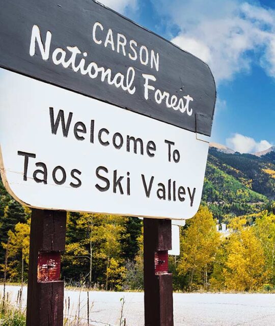 Carson national Forest sign at Taos Ski Valley with fall colors in the background.