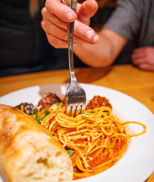 Fork twirling in spaghetti marinara and meatballs.