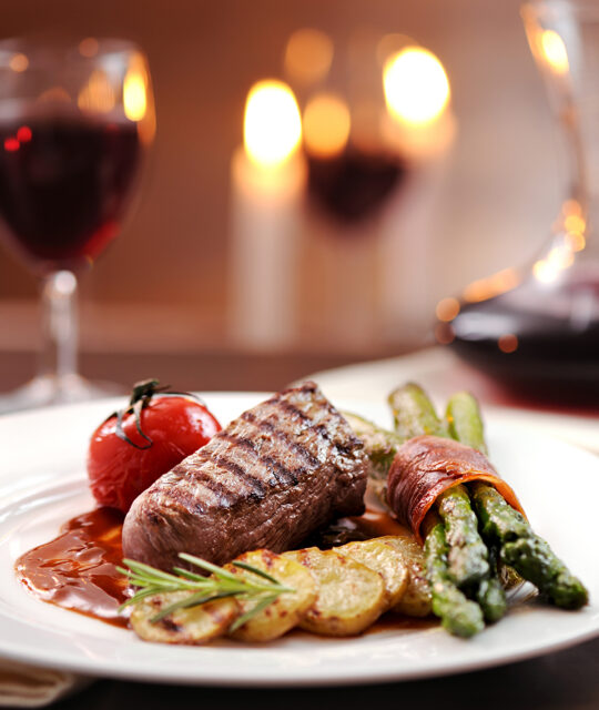 Grilled beef with prosciutto wrapped asparagus,tomato and grilled potato slices served with red wine