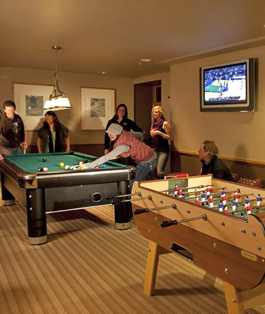 Friends gathered for a game of pool in a game room.