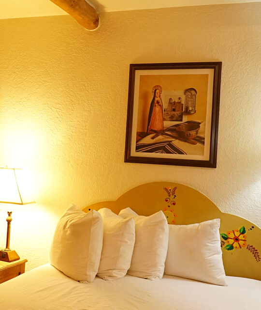 Cozy warm-lit hotel room with Native American art and soft bedding