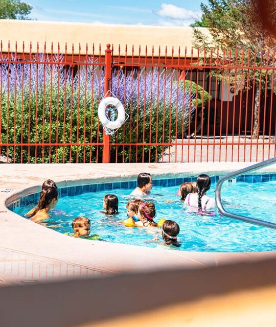 Family enjoying the pool at El Pueblo Lodge in Taos