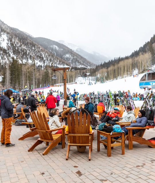 Crowds of people around an open fire at a ski resort