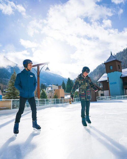 Couple ice skating at the Eis Haus ice skating rink in Taos Ski Valley.