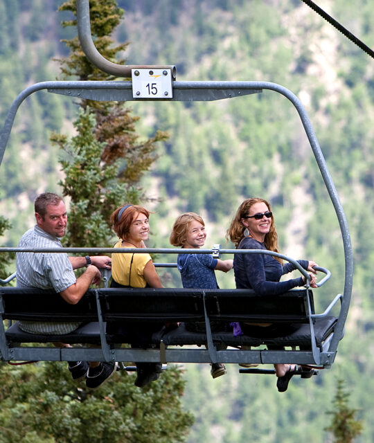 Family riding a ski chairlift in the summer